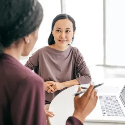 Woman looking at resumes as a recruiter and talking with candidate