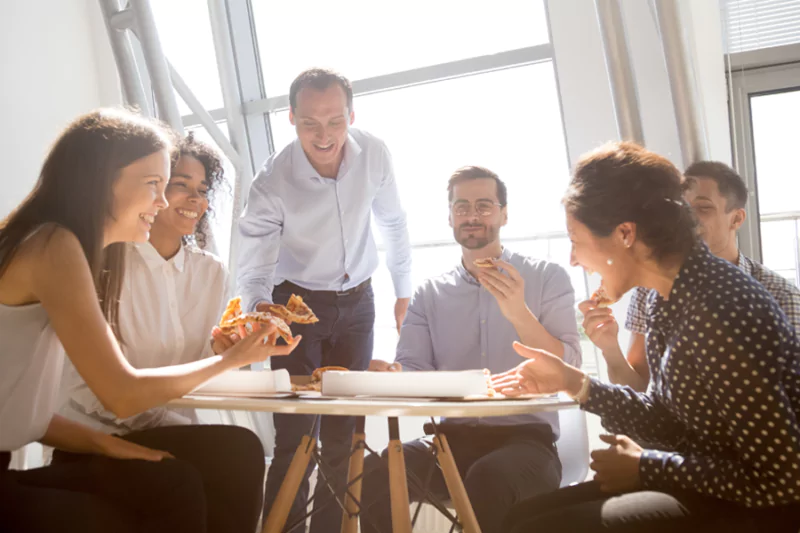 Group of people gathering eating pizza